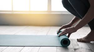 Rolling out a yoga mat for pilates